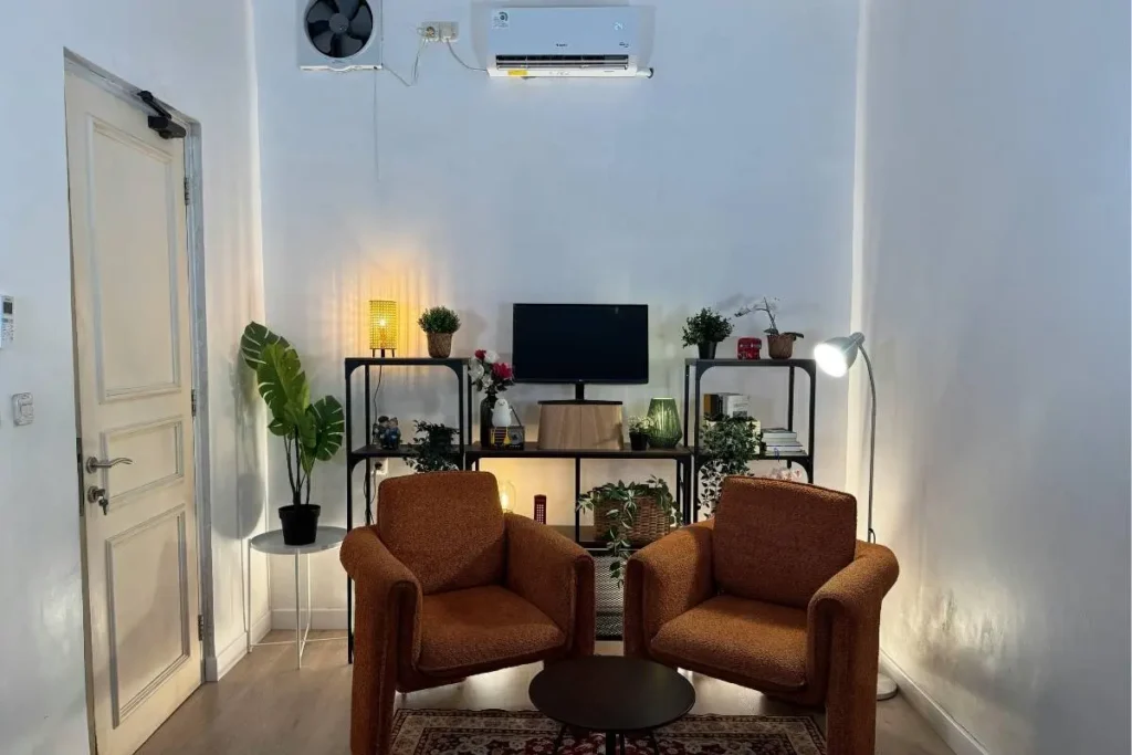 Layered lighting setup with warm lamp and floor lamp in a cozy apartment corner
