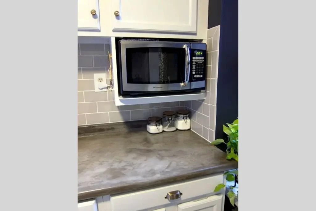 Where to put a microwave in a small kitchen with no counter space? 2 Stainless steel microwave installed in a wall-mounted shelf showing where to put microwave in small kitchen with no counter space.