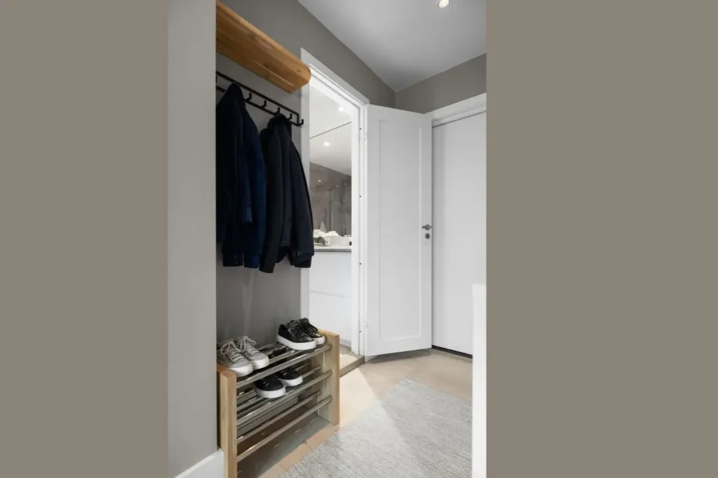 compact wooden shoe rack and coat hanging rail in narrow entryway nook